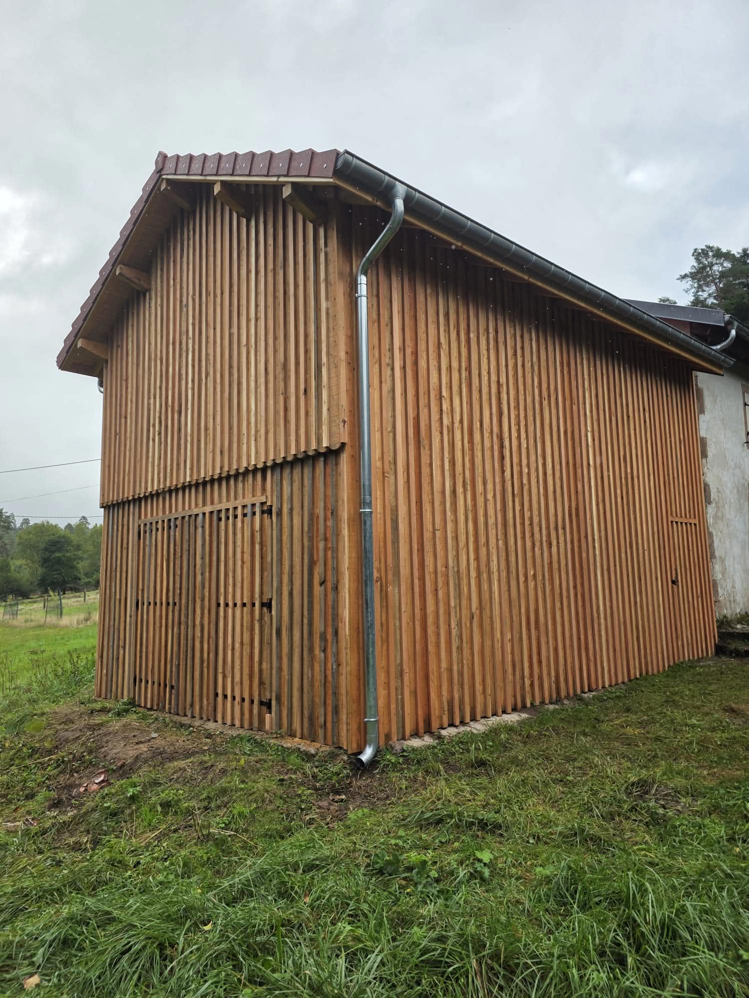 Bardage bois vertical sur abri — vue de côté